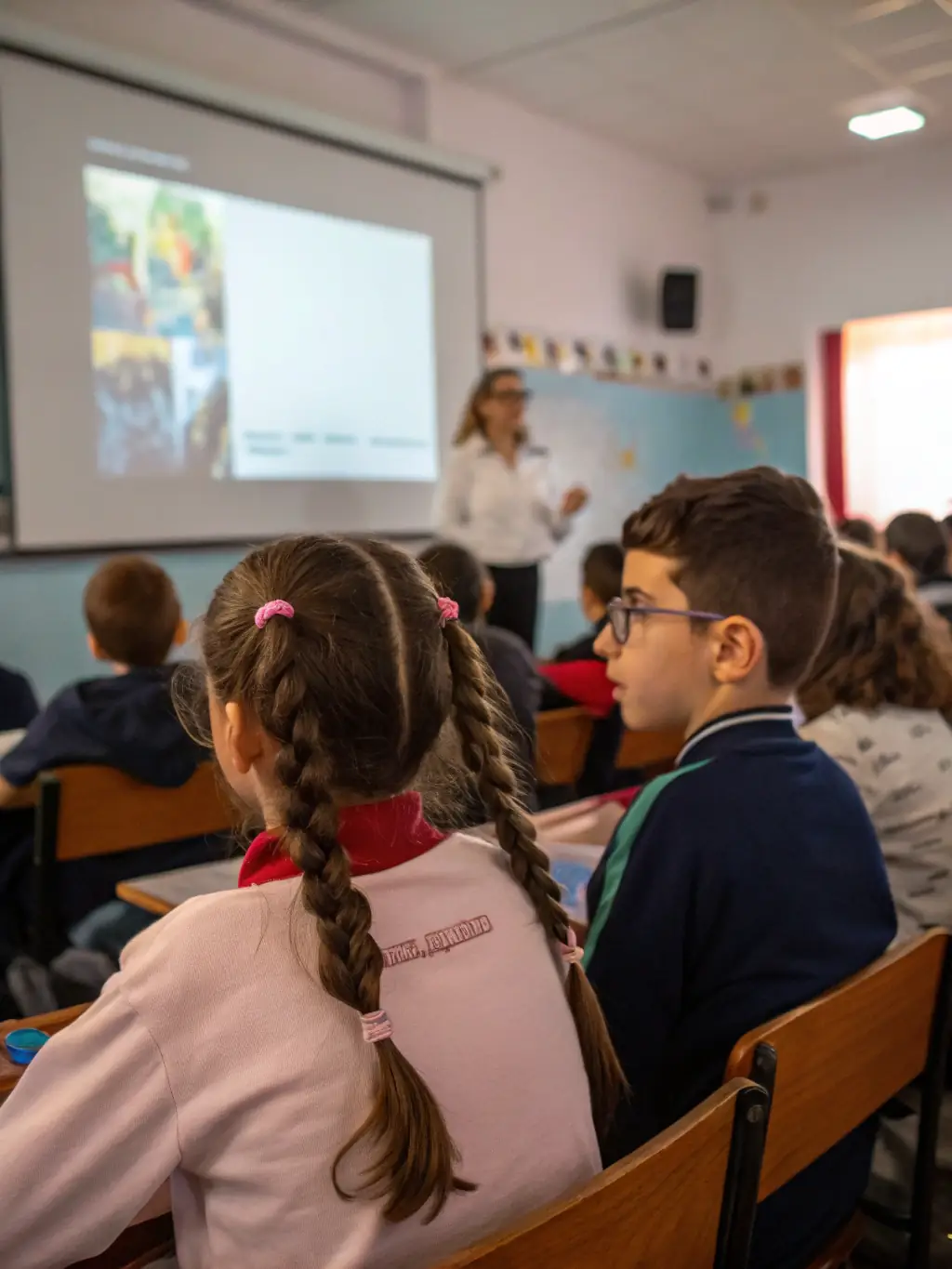 A group of students attentively watching a classic film screening in a classroom setting, highlighting CINEMATHEQUE IN CINEMA's educational outreach efforts.